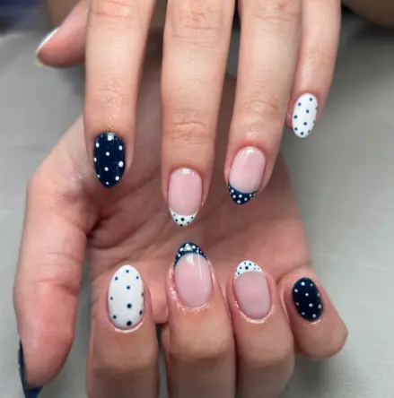 Navy blue nails with classic white polka dot design